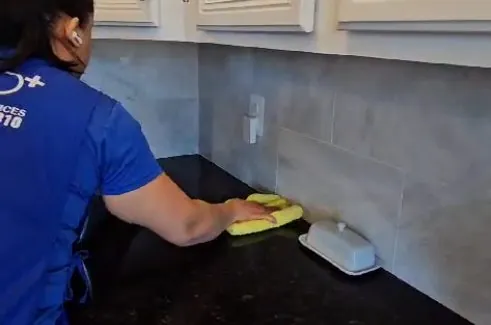 Professional cleaning a ceiling and high surfaces during a deep clean